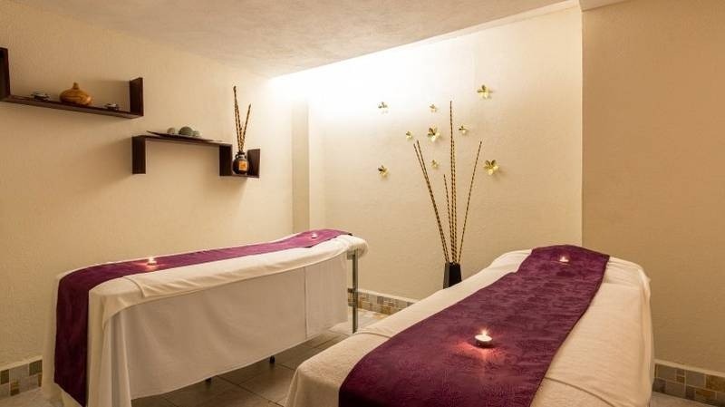 Zona de masajes con dos camillas, decoración zen e incienso del Hotel Park Royal Beach Acapulco
