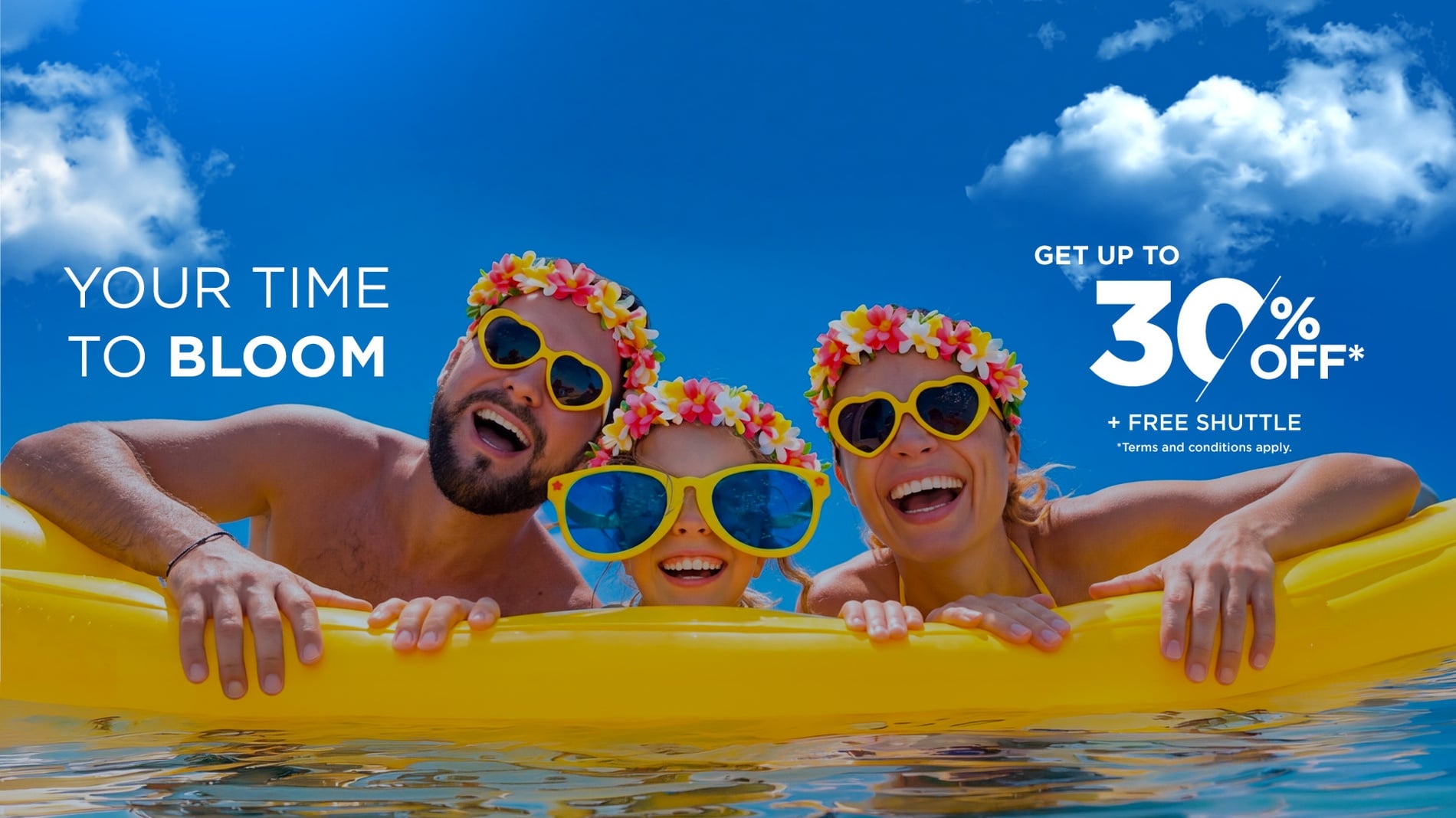 A happy family, wearing flower leis and sunglasses, smiles up at a bright blue sky, with promotional text advertising "YOUR TIME TO BLOOM" and "GET UP TO 30% OFF* + FREE SHUTTLE".