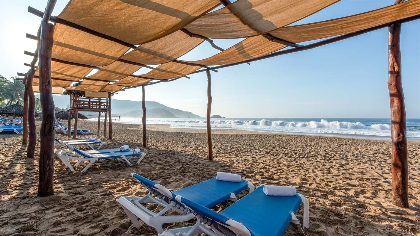 Hotel Park Royal Beach Ixtapa: tumbonas bajo sombrilla, playa y Pacífico Mexicano.