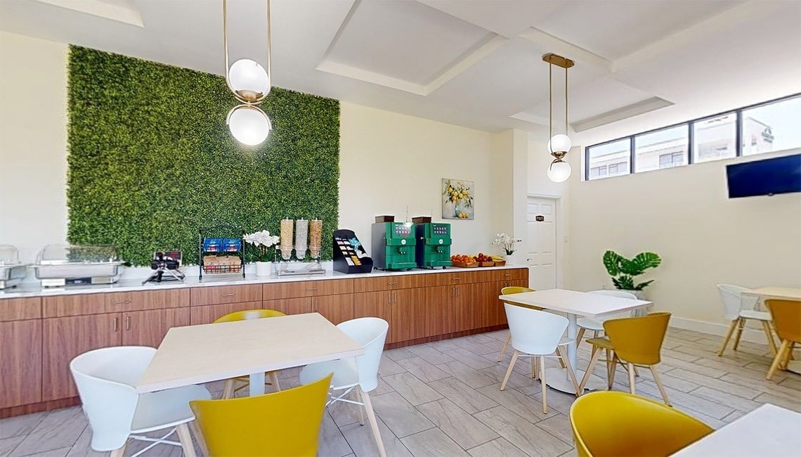 a dining room with tables and chairs and a green wall