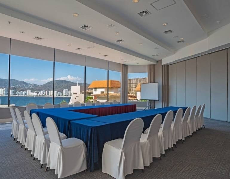 Área de eventos com cadeiras, projetor e mesa em U, com vista para o mar nos hotéis e resorts Park Royal