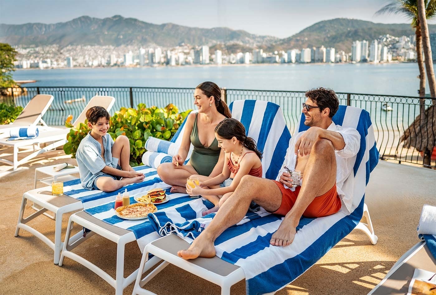 Familia relajándose en el Hotel Park Royal Beach Acapulco con vistas al Pacífico Mexicano.