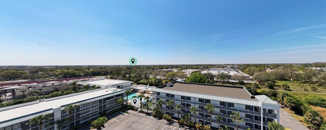 an aerial view of a hotel with a green pin pointing the location