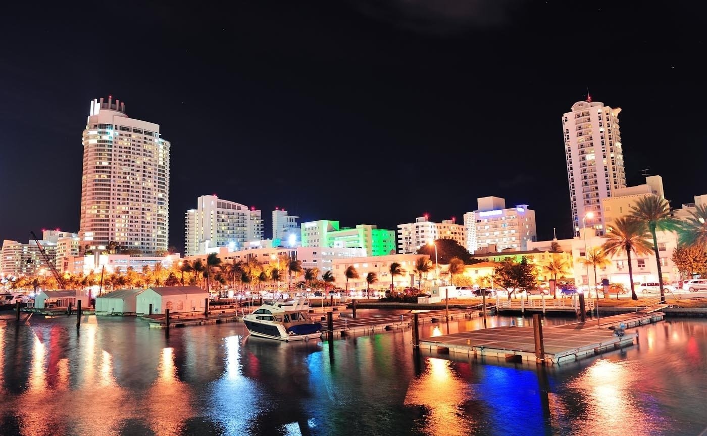 a boat is docked in front of a city at night