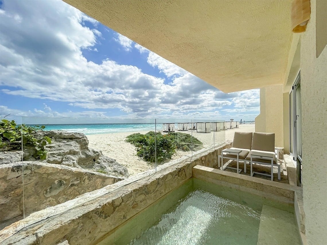 uma pequena piscina em uma varanda com vista para a praia