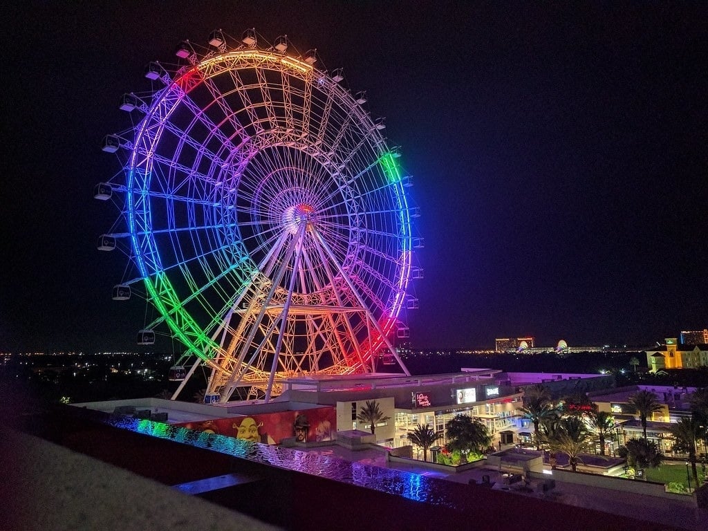 a large ferris wheel is lit up at night