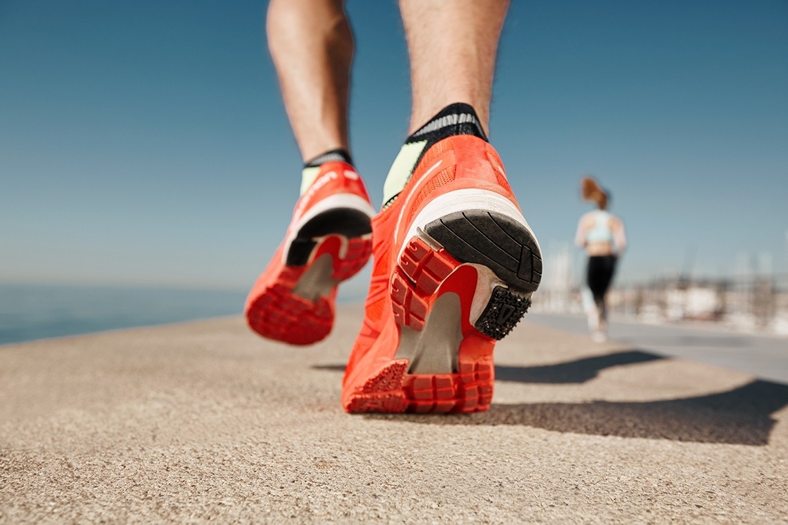 a person wearing a pair of orange nike shoes