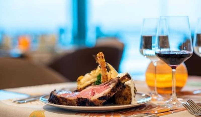 Detalle de plato de carne con verduras y copa de vino del restaurante Gran Prime Rib House, Hotel Grand Park Royal Cancún