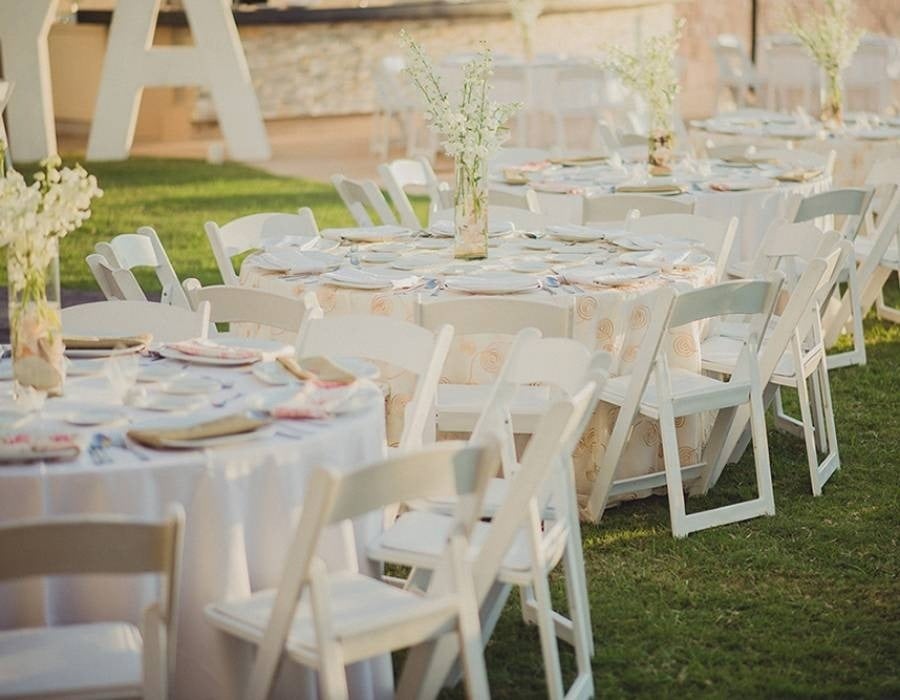 Mesas redondas com cadeiras decoradas para celebrar um casamento na praia no hotel Mazatlán, no México