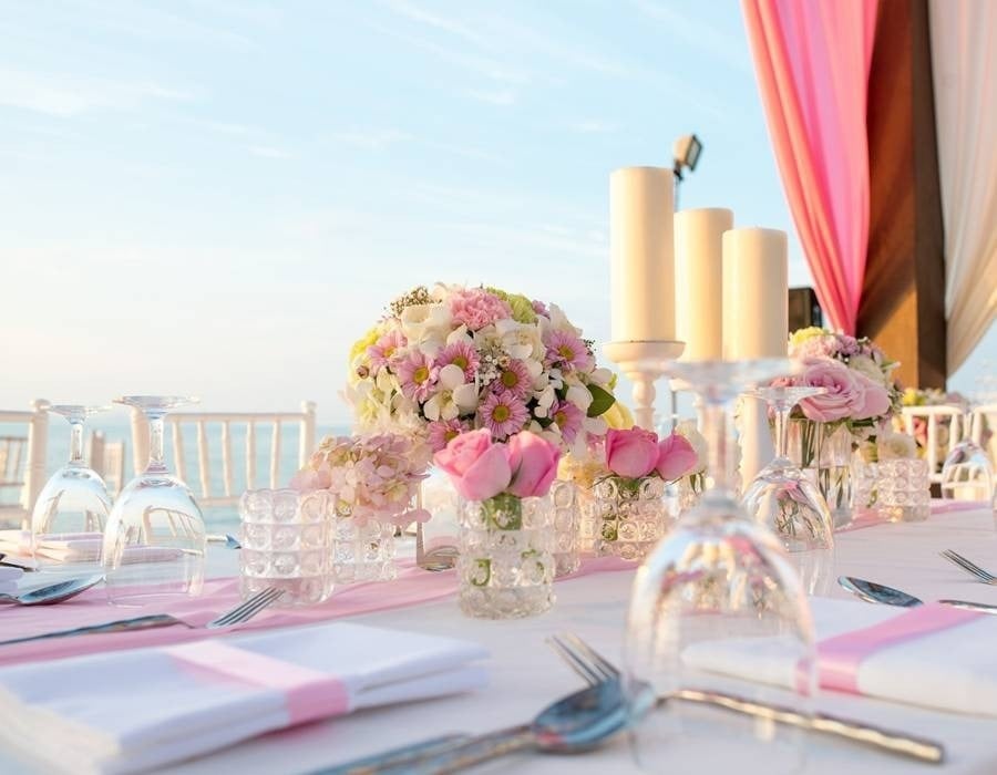 Mesa decorada com velas e flores para celebrar um casamento no resort Beach Mazatlán