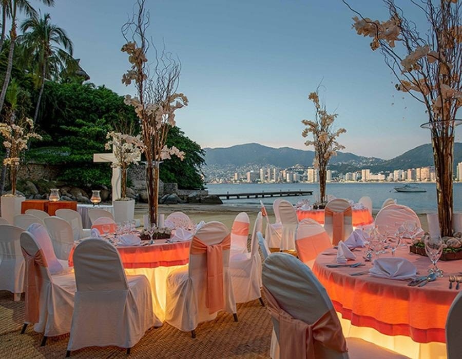 Mesas decoradas para invitados de boda en la playa del Hotel Park Royal Beach Acapulco