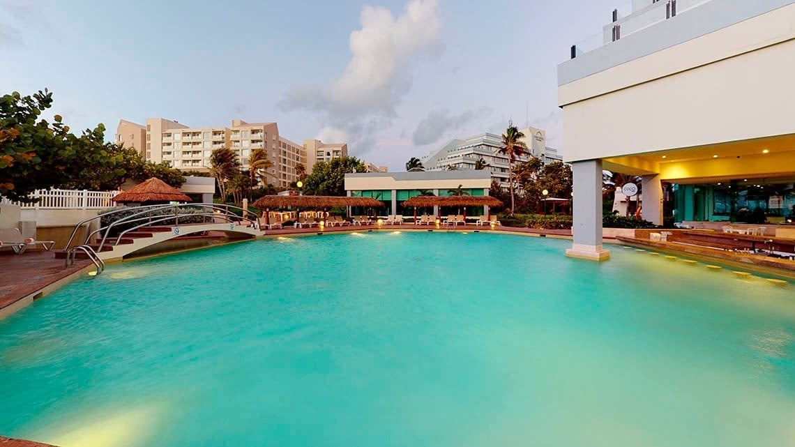 Piscina ao ar livre ao pôr do sol no Park Royal Beach Cancun Hotel
