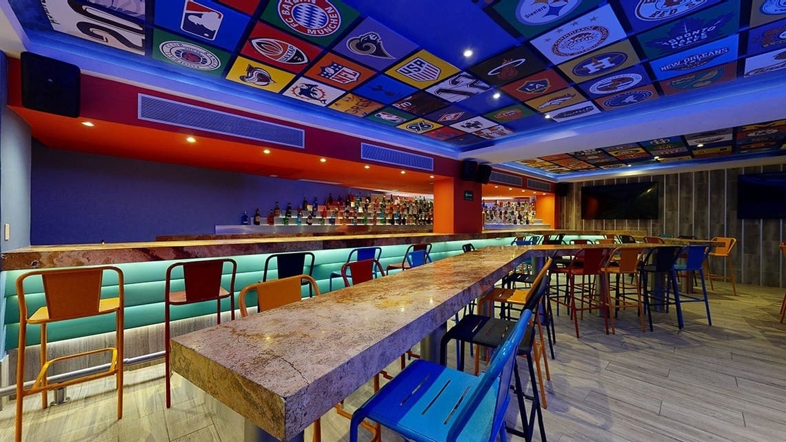 Área de bar com bancos e um amplo bar no Hotel Grand Park Royal Puerto Vallarta
