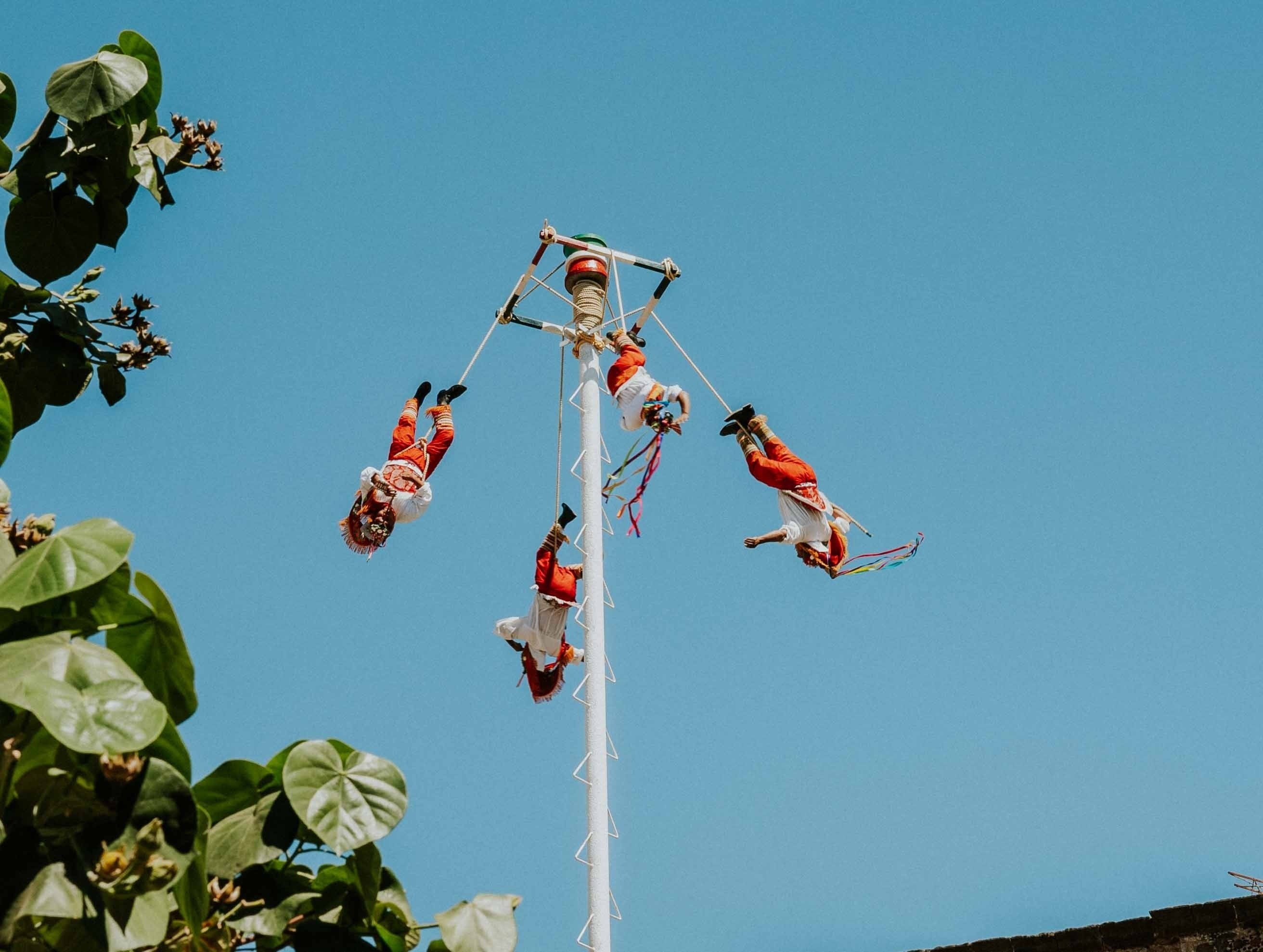 un grupo de hombres vuelan en el aire en un poste