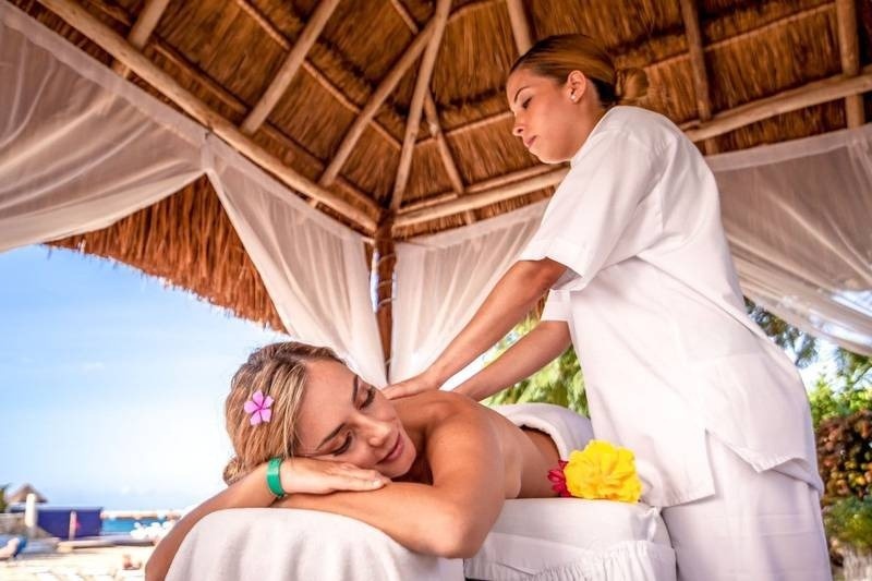 Mujer recibiendo un masaje en la zona de wellness del Hotel Grand Park Royal Cozumel