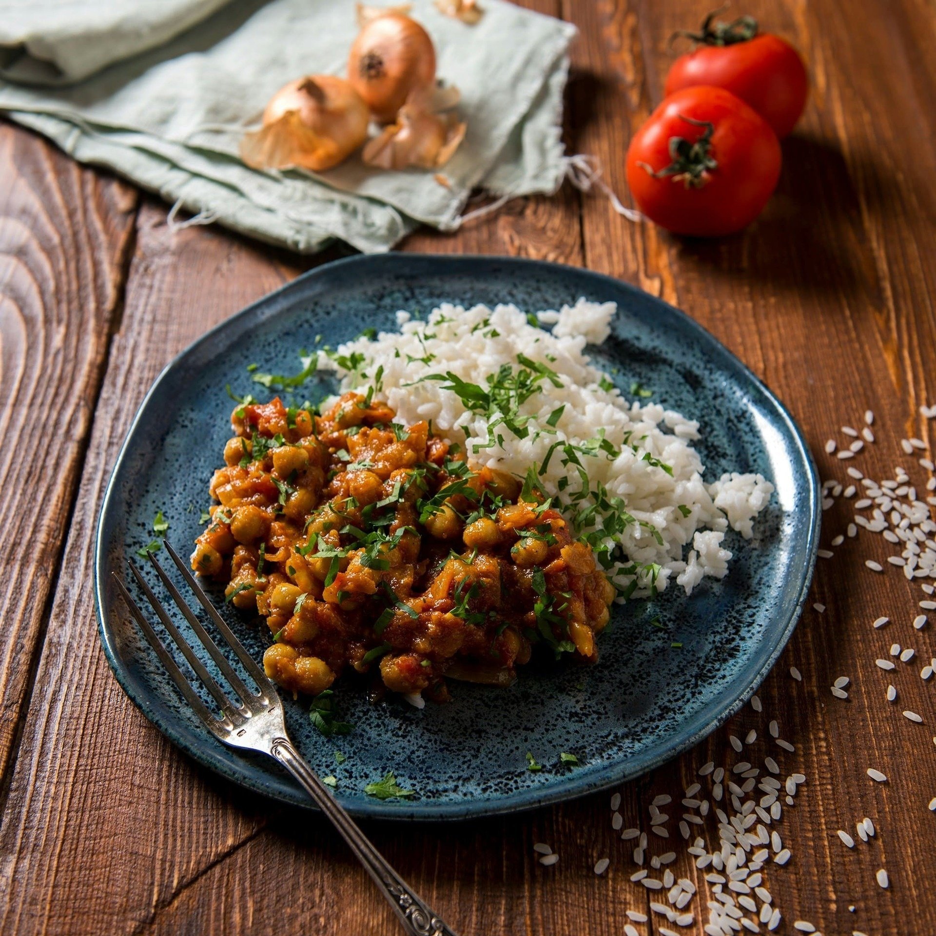 un plato azul con garbanzos y arroz sobre una mesa de madera