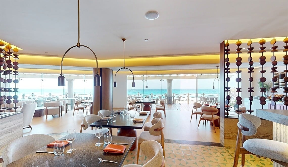 a restaurant with tables and chairs and a view of the ocean