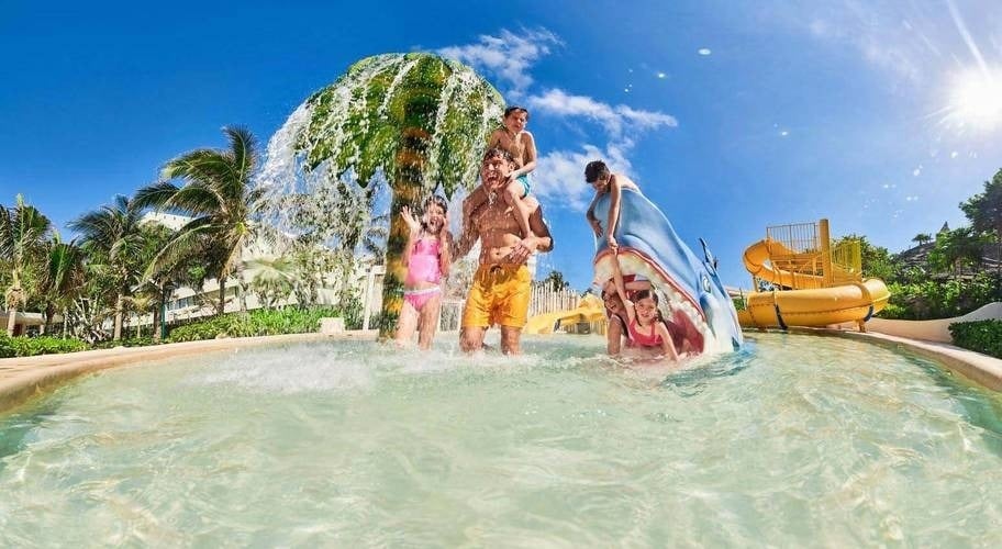 Padre con sus hijos disfrutando del parque acuático del Hotel Park Royal Beach Cancún