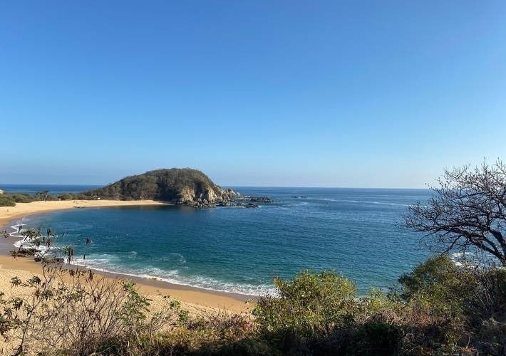 una playa con una pequeña isla en el medio del océano .