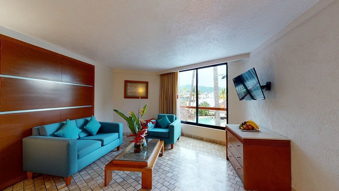 Living room con sofás y mesa central de una habitación del Hotel Park Royal Beach Acapulco
