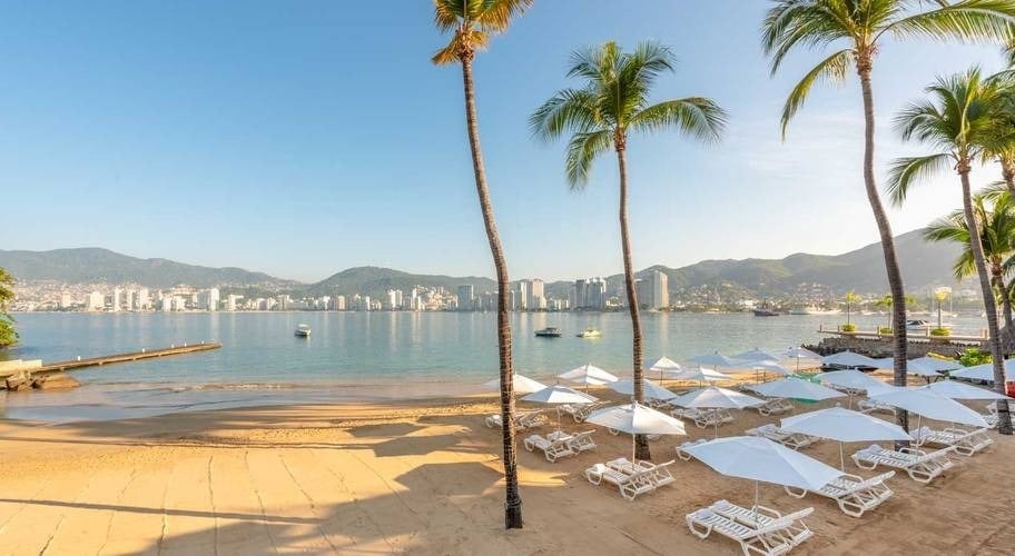 Praia privada com redes e palmeiras no Park Royal Beach Acapulco, México