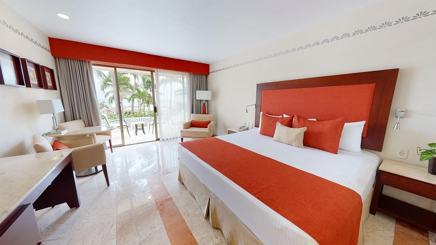 Hotel Grand Park Royal Cancun: King bed with orange accents & ocean view patio. Official Web.