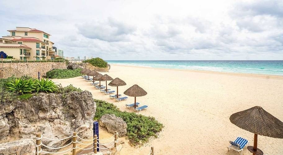 Praia com guarda-sóis e redes do Grand Park Royal Cancun Hotel no Caribe mexicano