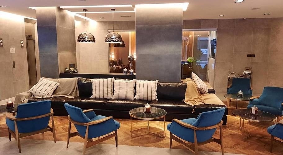 Área de recepção com sofás, almofadas e mesas