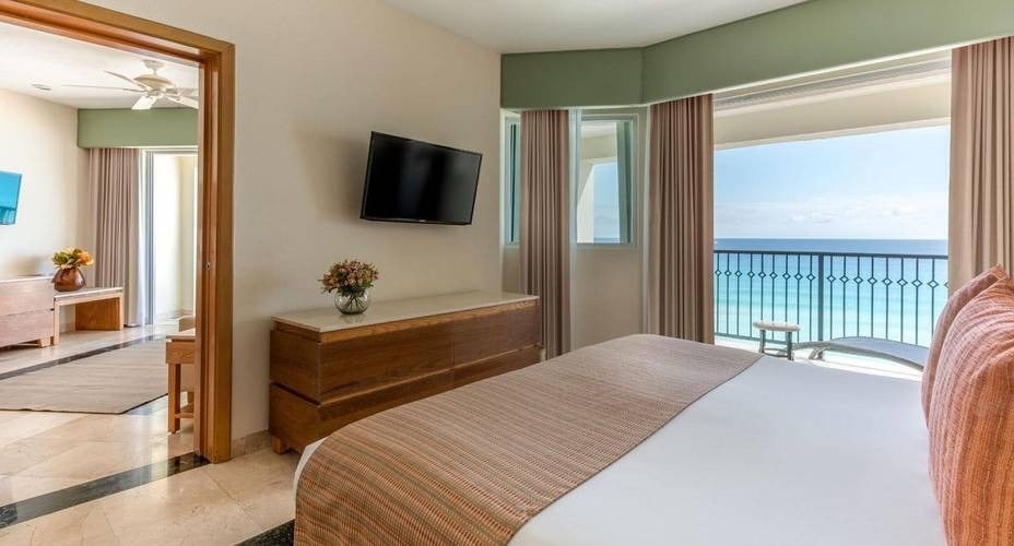Habitación con dos espacios (dormitorio y sala de estar) y terraza con vistas al mar Caribe del Hotel Grand Park Royal Cancún