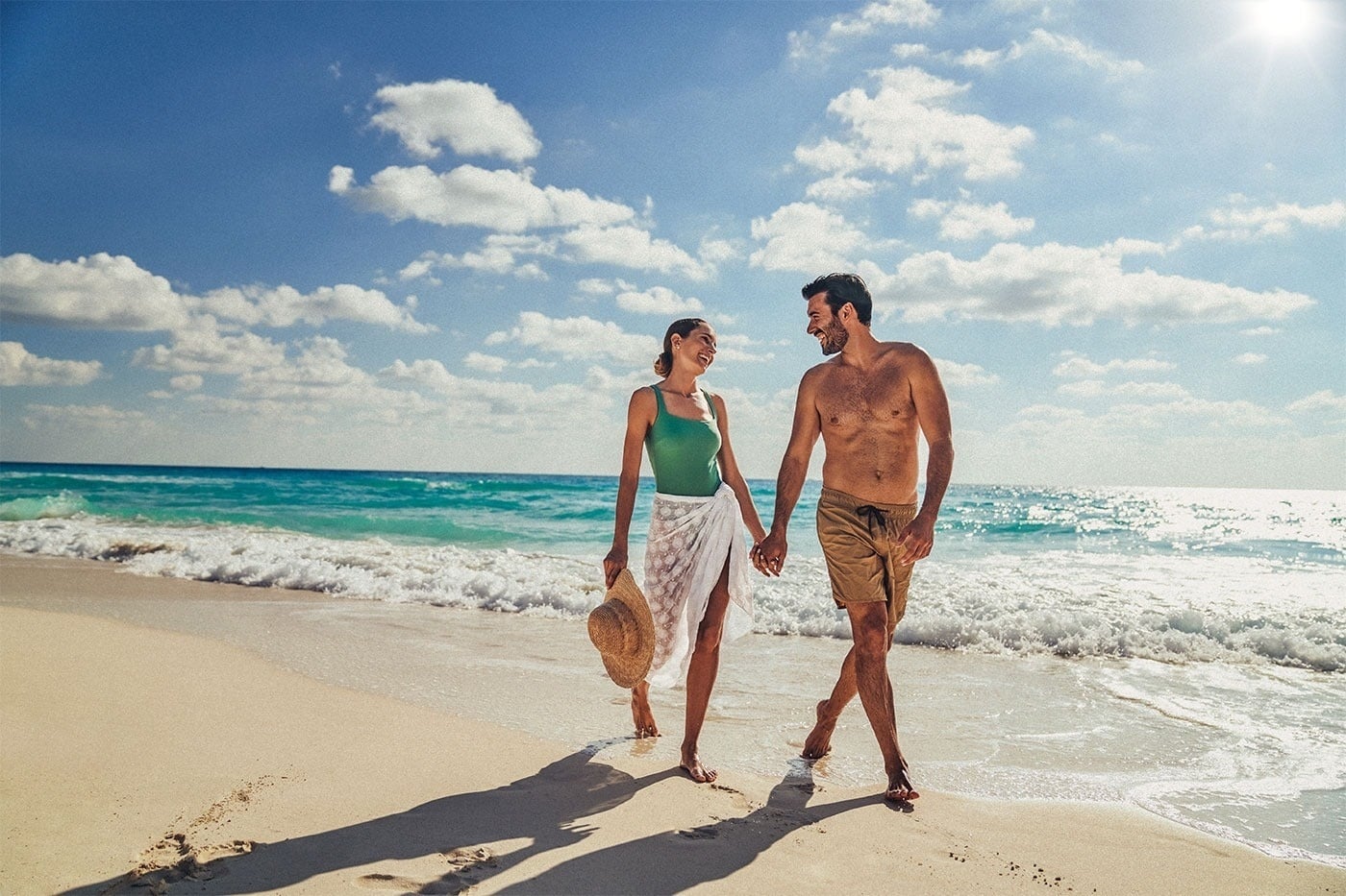 Pareja feliz caminando en la playa Royal Select at Grand Park Royal Cancún, Caribe Mexicano