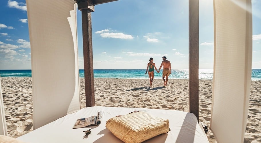 Mujer disfrutando del atardecer en una cama balinesa de Park Royal Grand Cancún