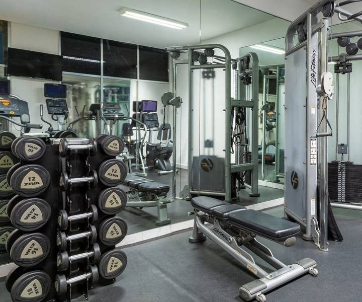 Gym with cardio machines and weights overlooking the sea