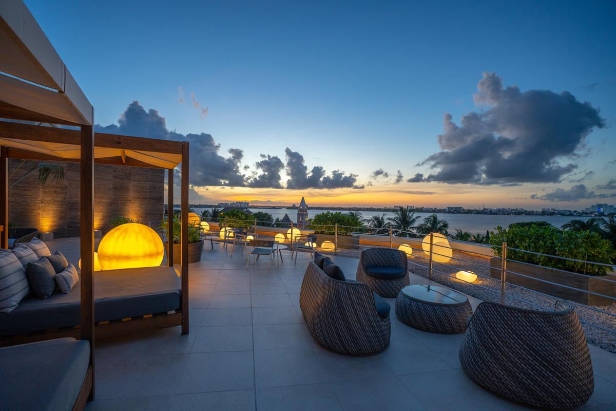 a patio with chairs and a canopy overlooking a body of water