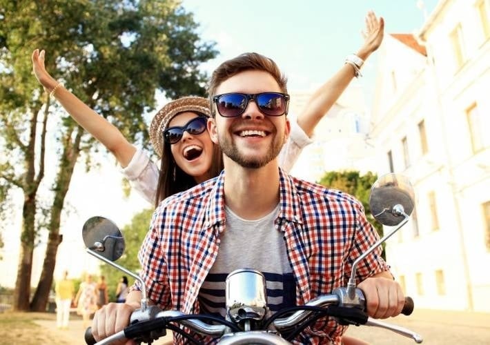 un hombre y una mujer están montando una motocicleta .