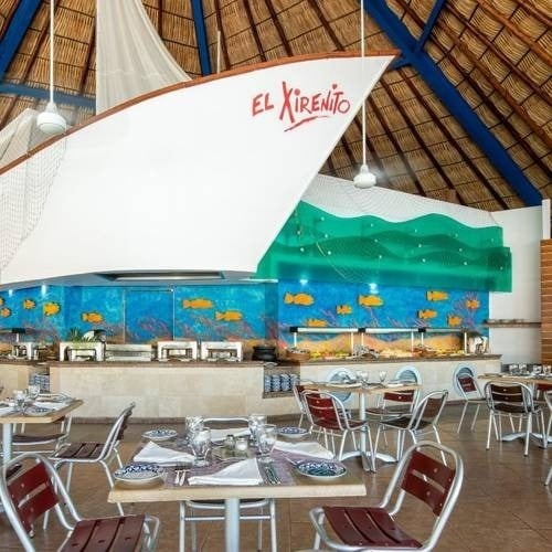 Restaurante El Pescador, con un bote llamado el sirenito y mesas alrededor del Hotel Park Royal Beach Acapulco