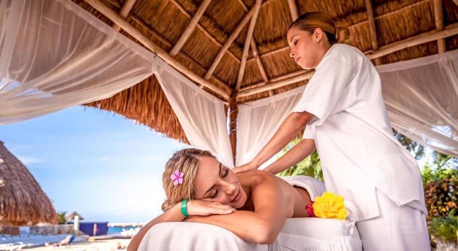 Área de bem-estar, mulher dando uma massagem no Hotel Grand Park Royal Cozumel