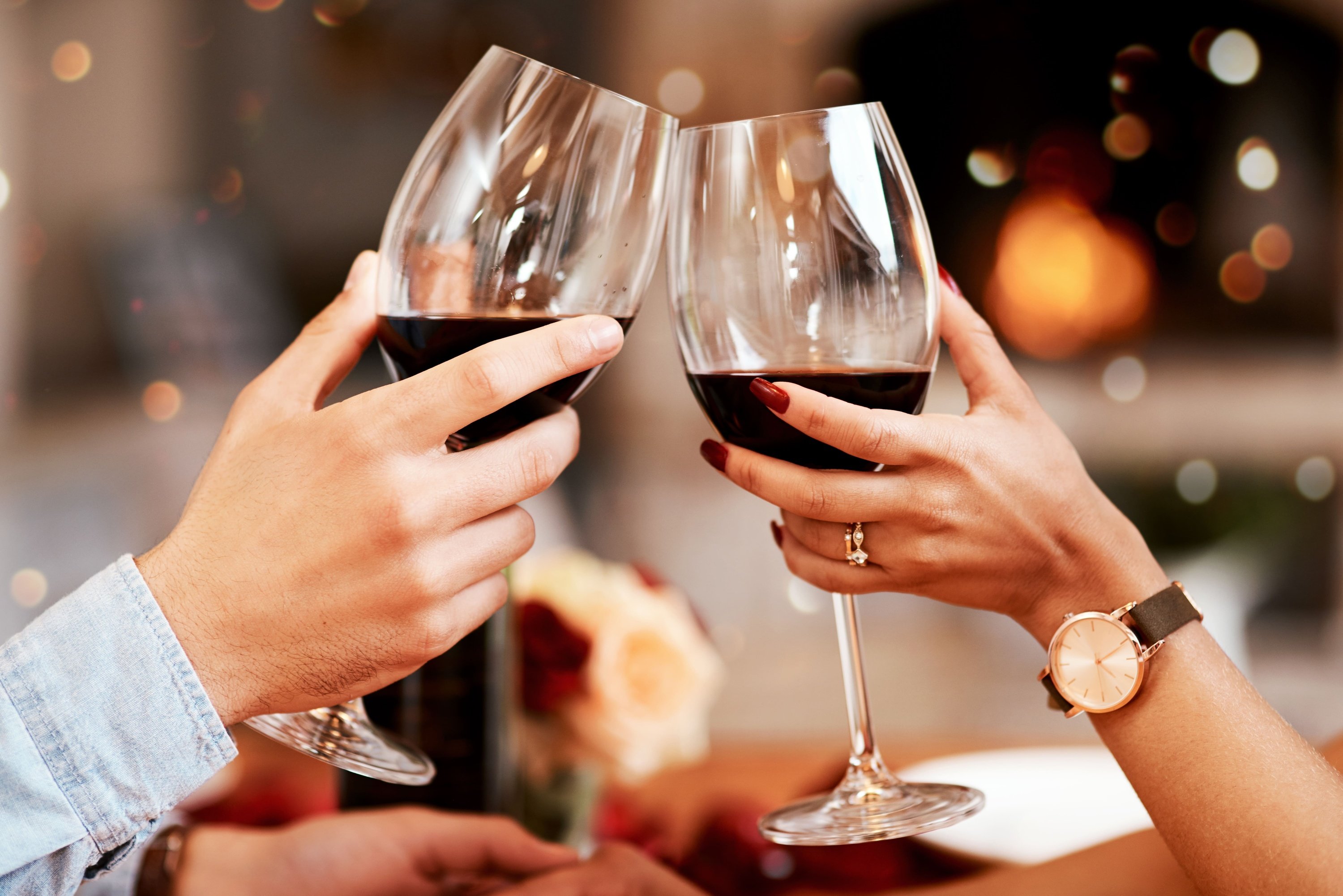 un hombre y una mujer brindan con copas de vino