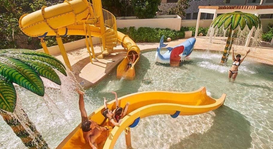Familia jugando en el parque acuático de hotel Park Royal Beach Cancún