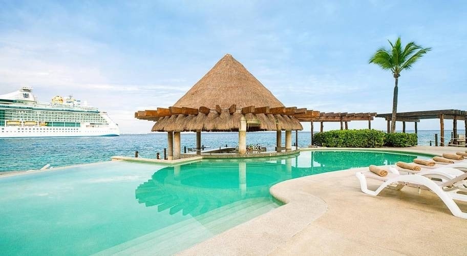 Bar com telhado de palha na piscina infinita com vista para o mar no Grand Park Royal Cozumel Hotel