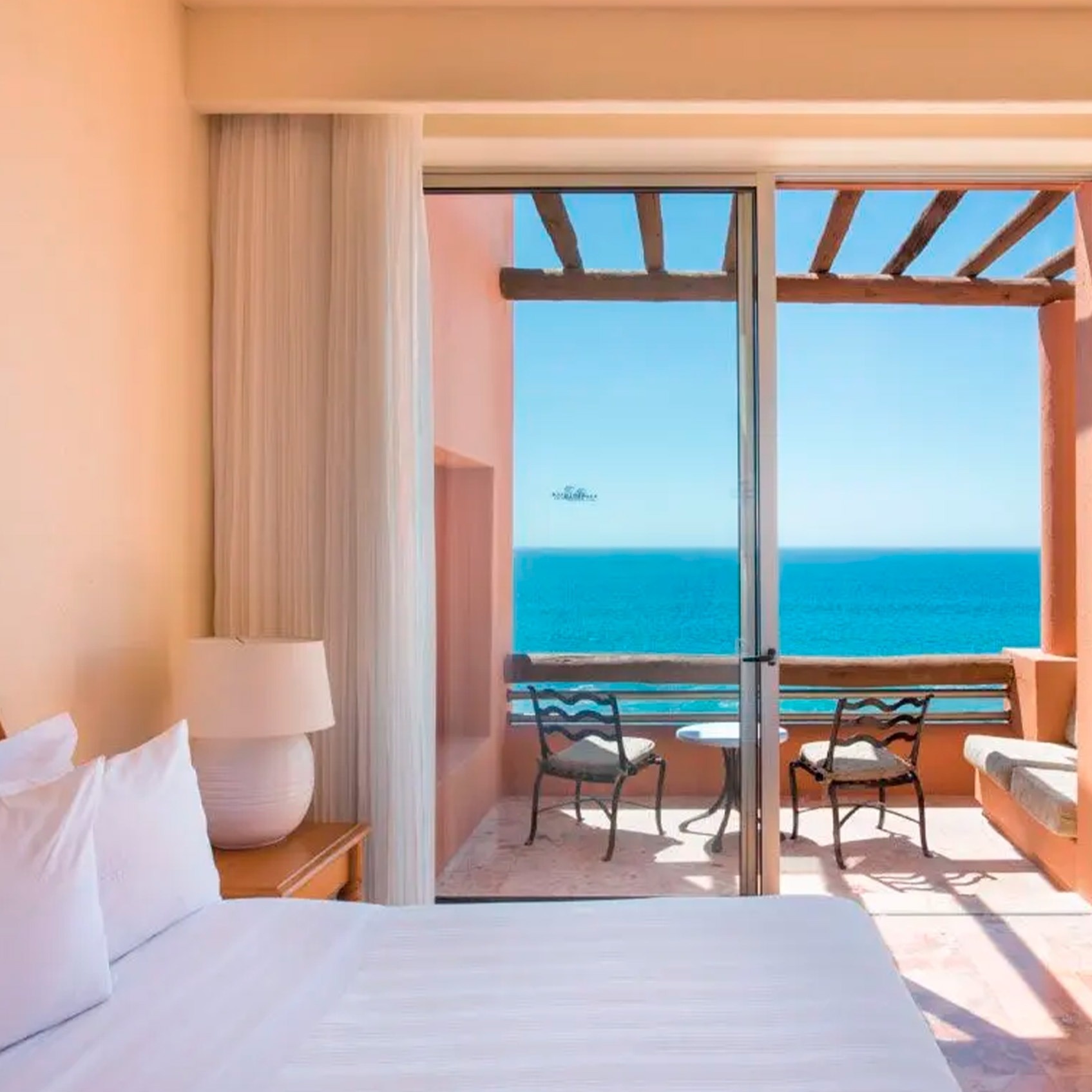 Habitación con vista al mar en Park Royal Club Regina Los Cabos. Balcón con sillas y mesa.