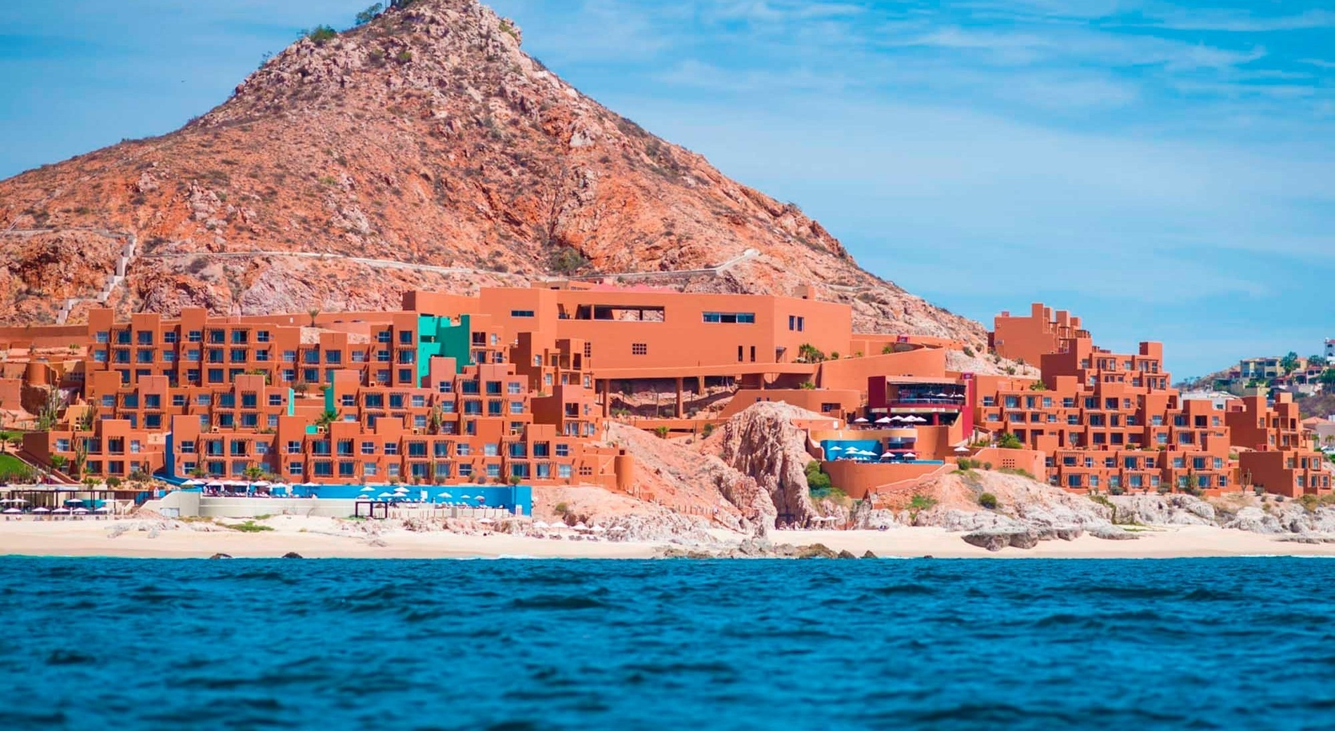 Park Royal: Club Regina Los Cabos, resort naranja frente al mar con montaña.