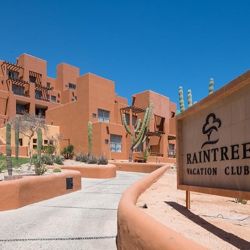 Edificio del Raintree Vacation Club con cactus y cielos azules. Club Regina Los Cabos.