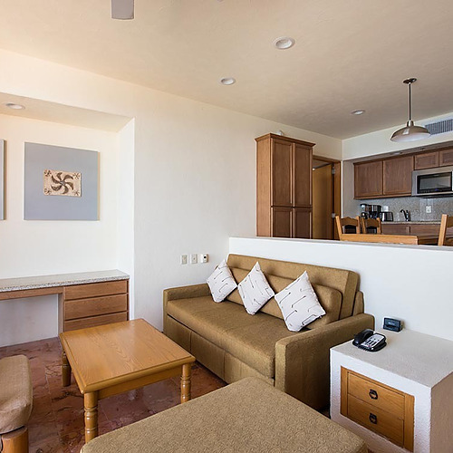 Comedor y sala de estar de Park Royal: Club Regina Los Cabos con sofá y escritorio.