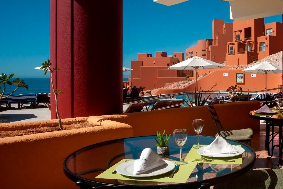 Mesa en terraza de Park Royal: Club Regina Los Cabos con vistas a piscinas y arquitectura.