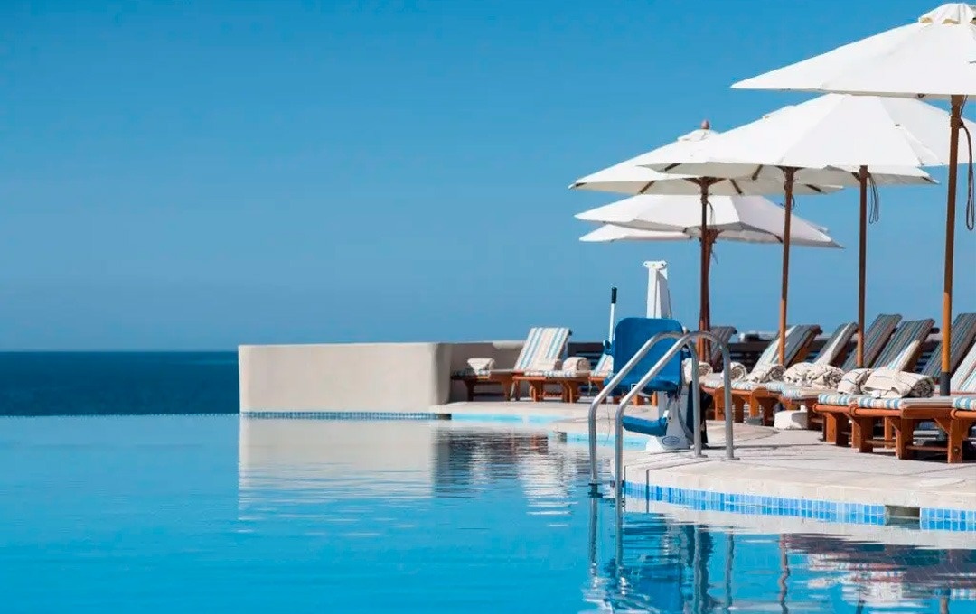 Infinity pool de Park Royal: Club Regina Los Cabos con camastros y sombrillas.