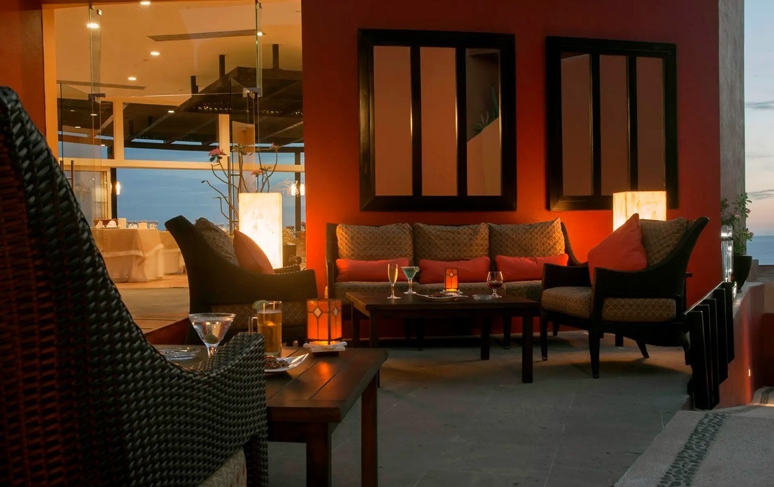 Terraza de Park Royal: Club Regina Los Cabos con sofás, sillas y vistas al mar.