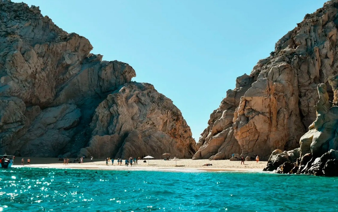Hermosa playa en Park Royal: Club Regina Los Cabos, rodeada de acantilados y mar turquesa.