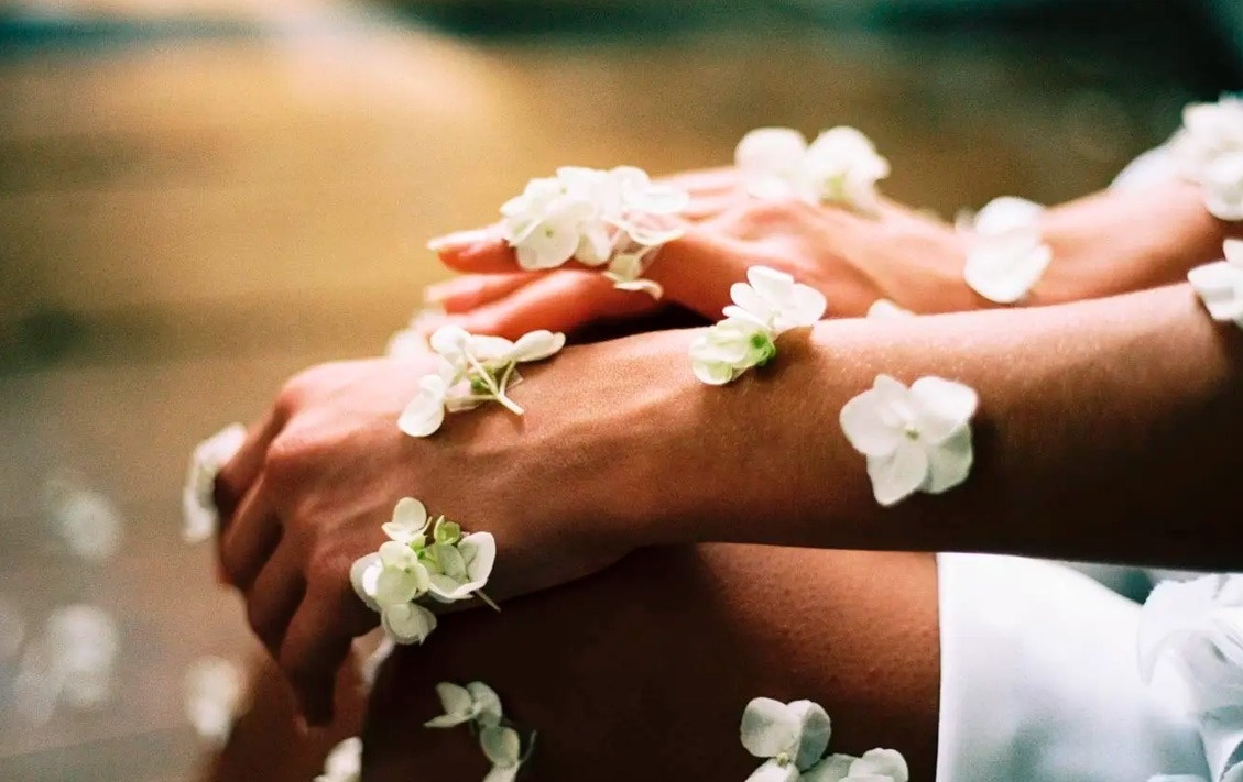 Manos adornadas con flores, evocando serenidad en Park Royal: Club Regina Cancun.