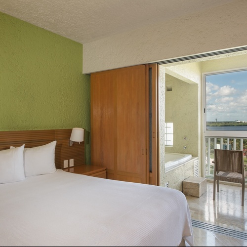 Suite de lujo en Park Royal: Club Regina Cancún con bañera y vista al mar.