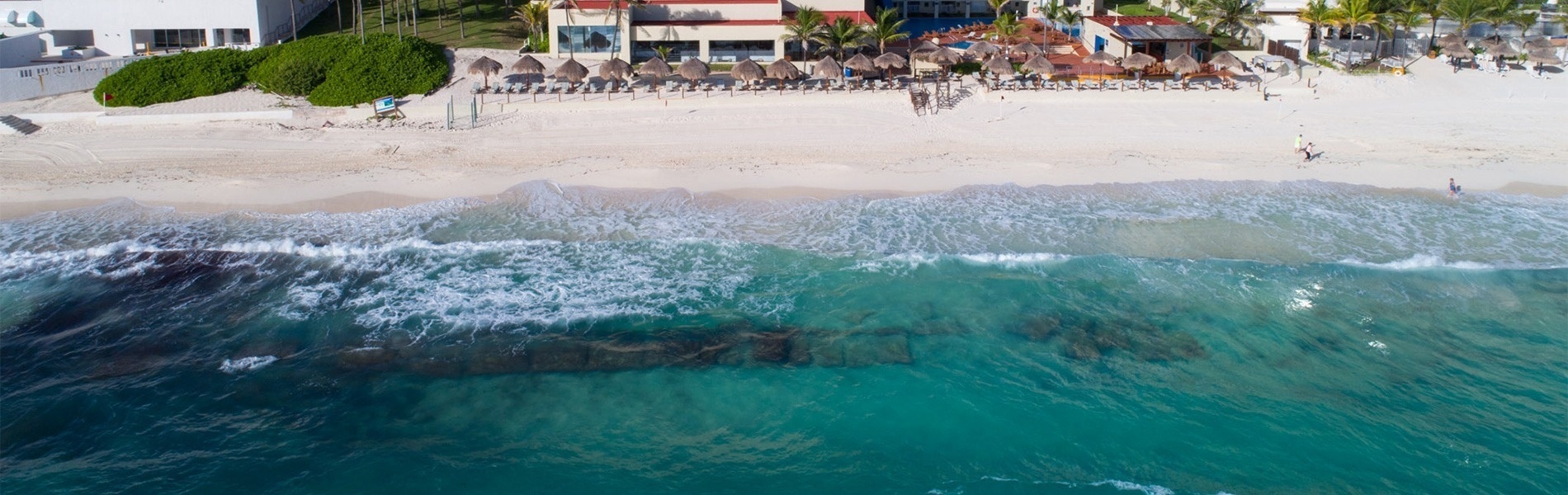 Hermosa vista aérea de la playa del Park Royal: Club Regina Cancun con aguas turquesas y palmeras.